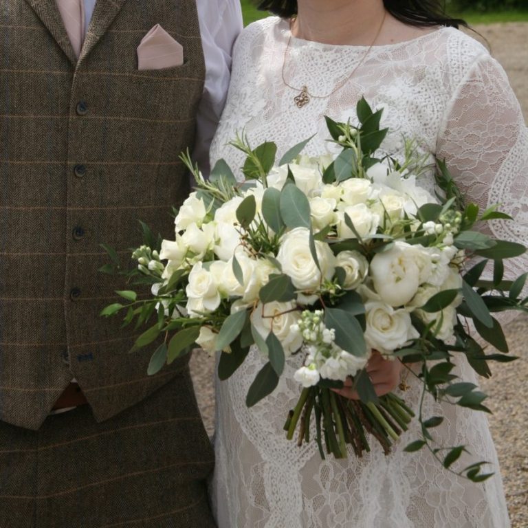 Classic green and white wedding bouquet with roses, peonies, stocks and greenery.